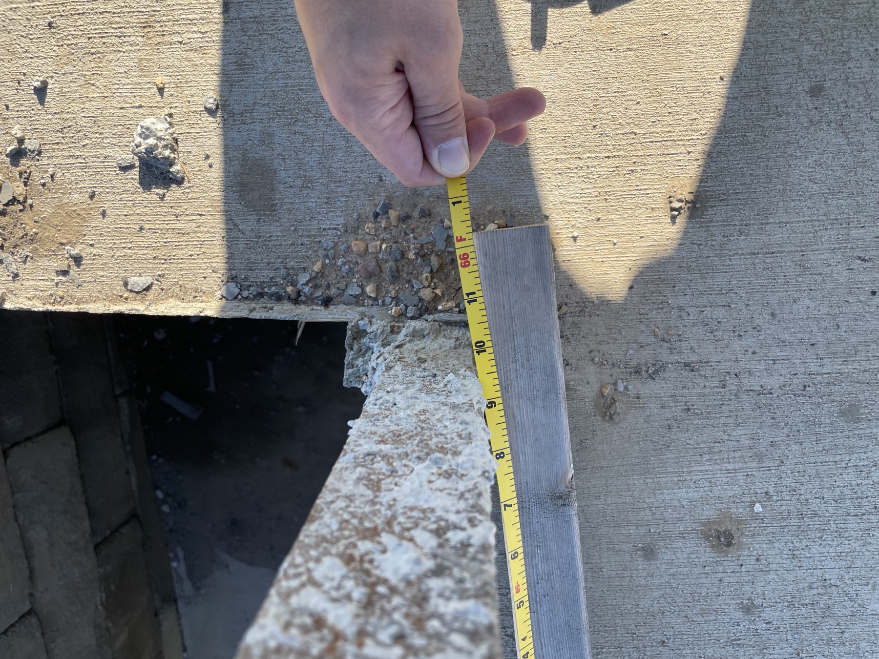 A tape measurement being recorded at a concrete field condition.